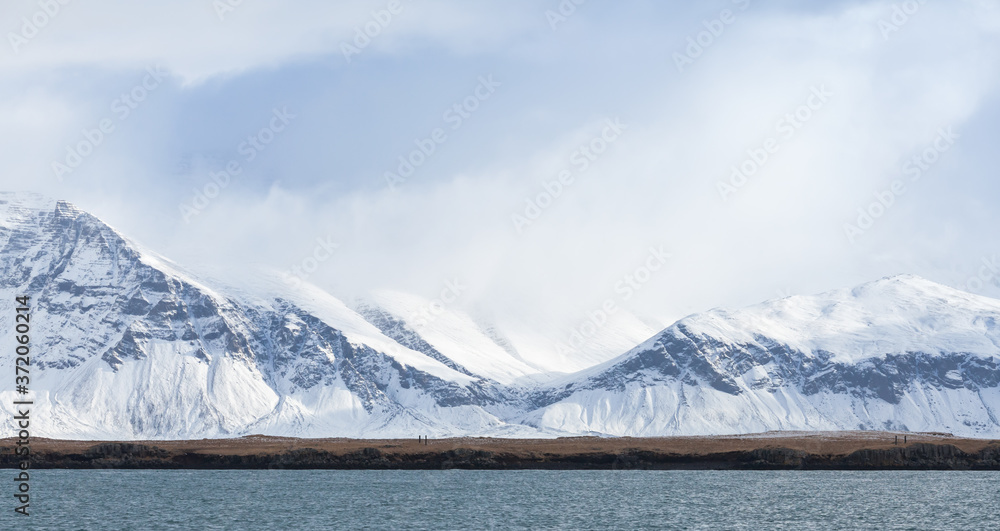 Icelandic landscape with coastal snowy mountains Icelandic landscape with coastal snowy mountains