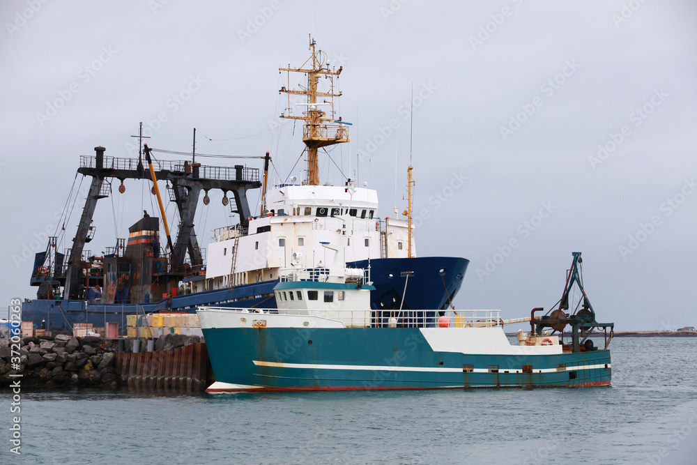 Industrial trawler ships stand moored in port