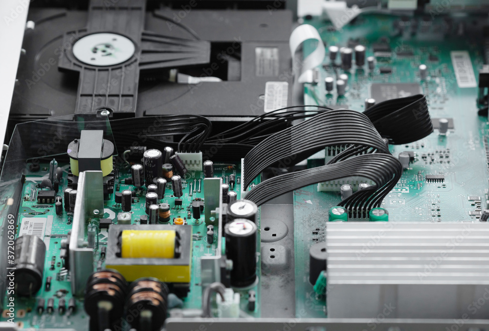 A close-up microchip with many electrical components placed on the Board. The background is blurred. A close-up microchip with many electrical components placed on the Board. The background is blurred.