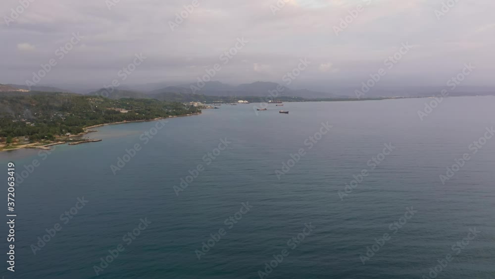 Coast with the city of Iligan in the background of mountains at sunset time. Mindanao, Philippines. Coast with the city of Iligan in the background of mountains at sunset time. Mindanao, Philippines.