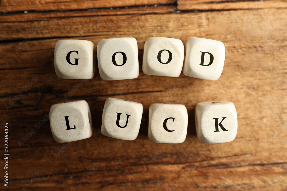 Cubes with phrase GOOD LUCK on wooden table, flat lay Cubes with phrase GOOD LUCK on wooden table, flat lay