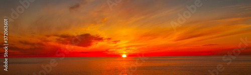Beautiful Orange and Yellow Golden Hour Sunset over the Ocean © Tony