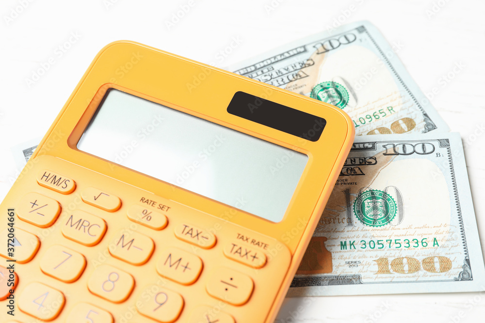 Calculator and money on white wooden table, closeup. Tax accounting Calculator and money on white wooden table, closeup. Tax accounting