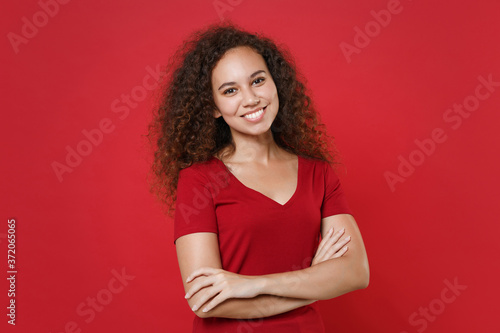 Canvastavla Smiling young african american woman girl in casual t-shirt posing isolated on red background studio portrait