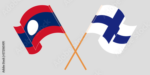 Crossed and waving flags of Laos and Finland