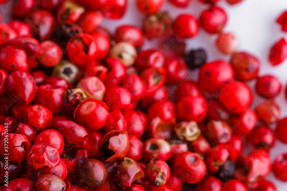 fragrant pink peppercorns on white acrylic background fragrant pink peppercorns on white acrylic background