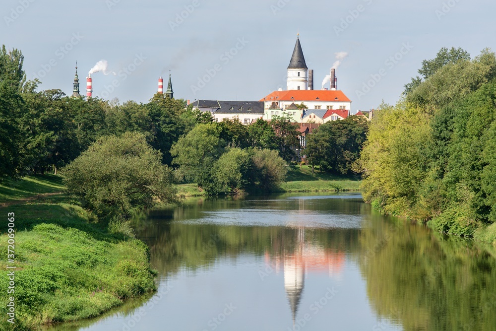 View of the tower and chimneys of the city from the bridge over the Becva River. Central Moravia. Czechia. Europe. 