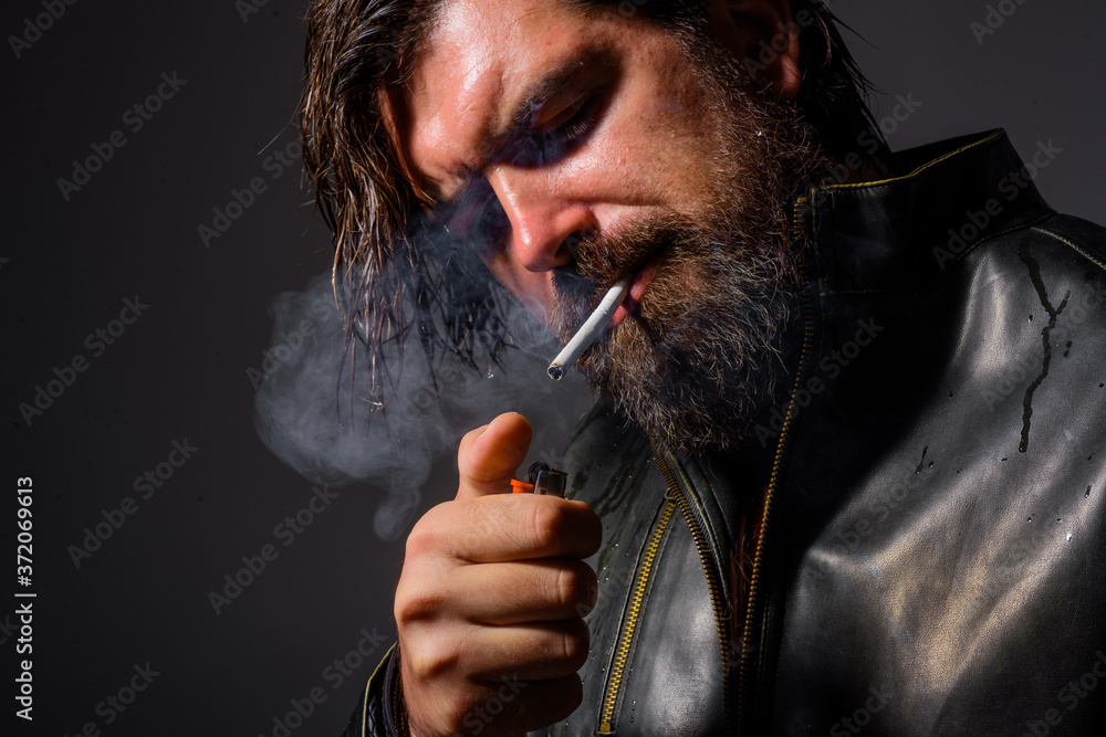 Fototapeta premium Smoking man. Bearded man smoking cigarette. Cigarette smoke. Tobacco. Bearded man with cigarette. Man smoke the cigarette.