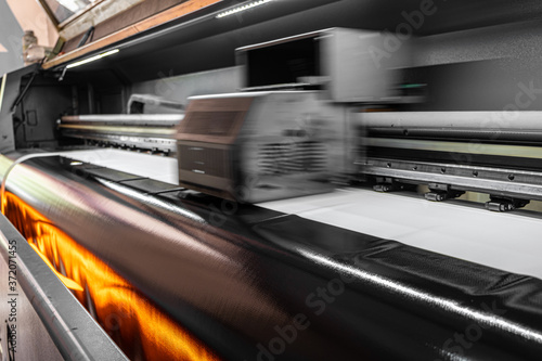 Drying the prints by heating. Printing machine that dries the print with its heated fans. Large format digital printing machine and moving print head. 