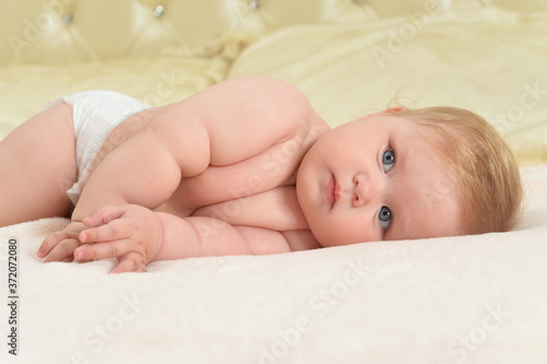 Cute little baby girl on bed lying