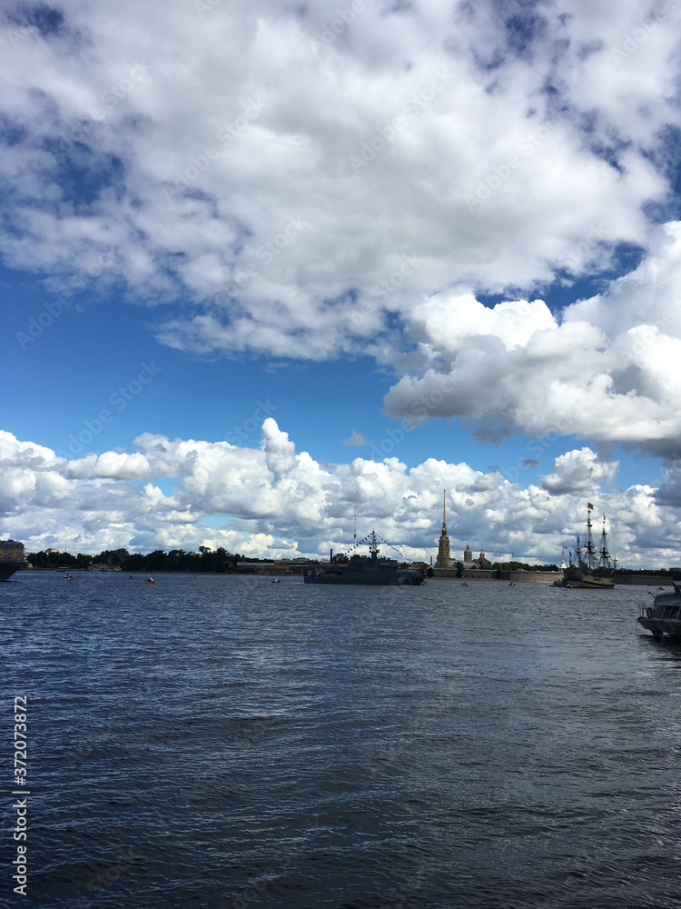 Water area of the Neva river, where there are warships with flags and the sailing ship Poltava, who arrived to participate in the naval parade in St.Petersburg 