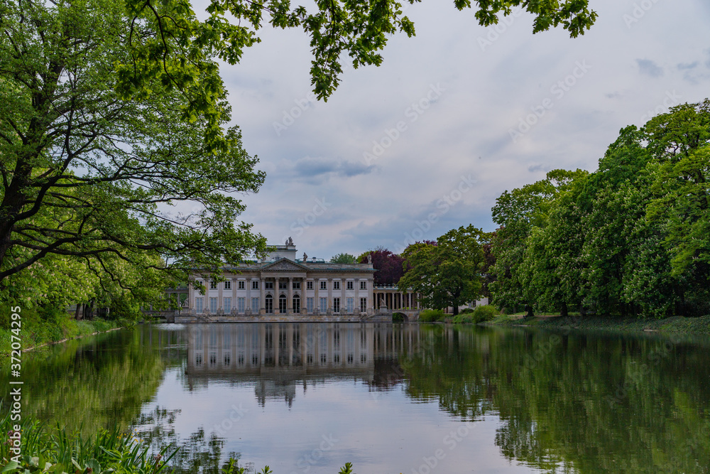 Palace on the Isle, Baths Palace is reflected in the water across the lake in Royal Baths Park is the largest park in Warsaw, Poland Palace on the Isle, Baths Palace is reflected in the water across the lake in Royal Baths Park is the largest park in Warsaw, Poland