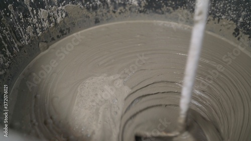 The solution is in a bucket. fresh wet grout inside a bucket close-up. Macro shot of a mortar in a bucket.