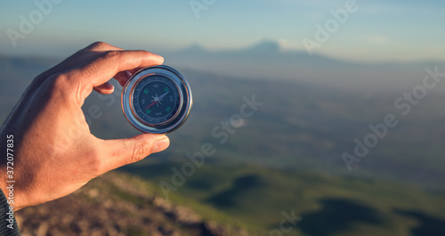 man hand compass in mountain