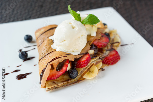 crepe with strawberry, blueberry, banana, vanilla ice cream drizzled chocolate syrup