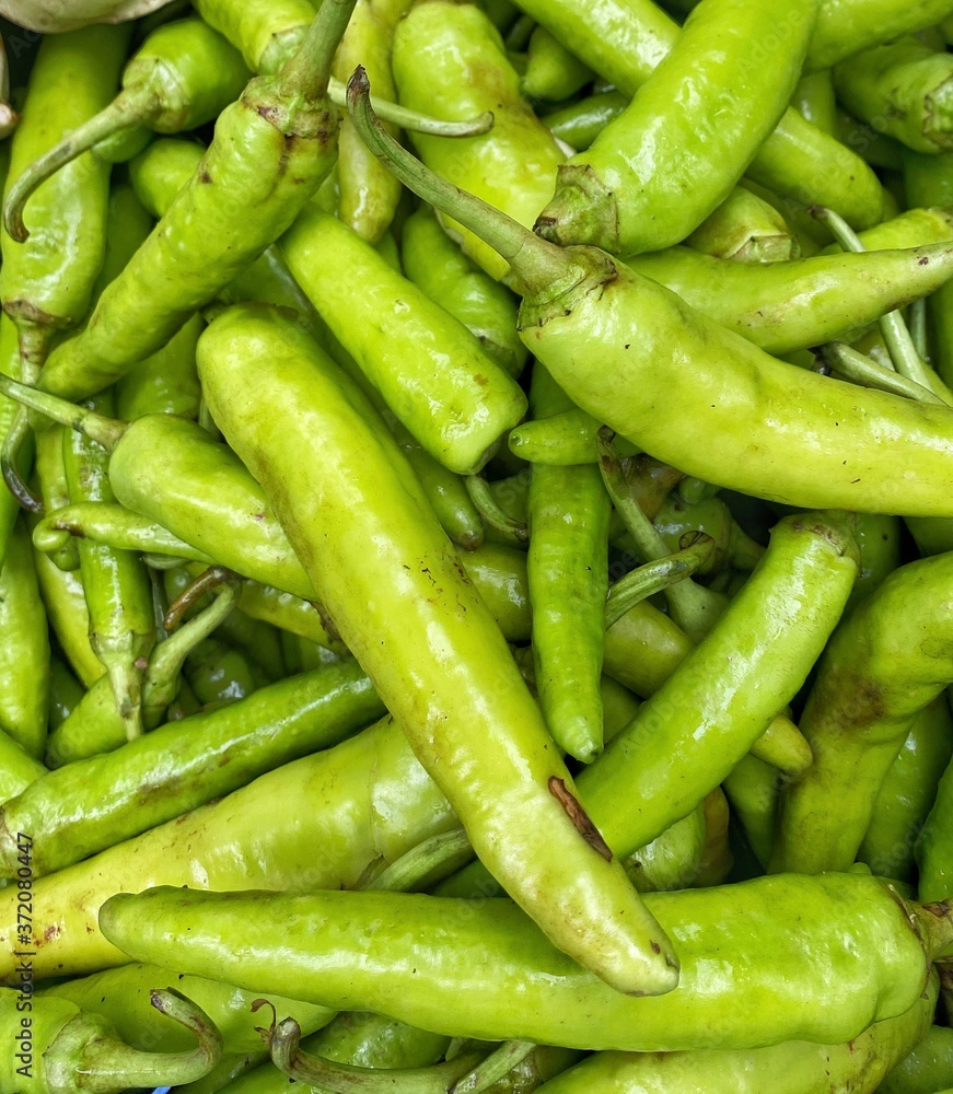 Fresh Indian green chillies stacked up in a market Fresh Indian green chillies stacked up in a market
