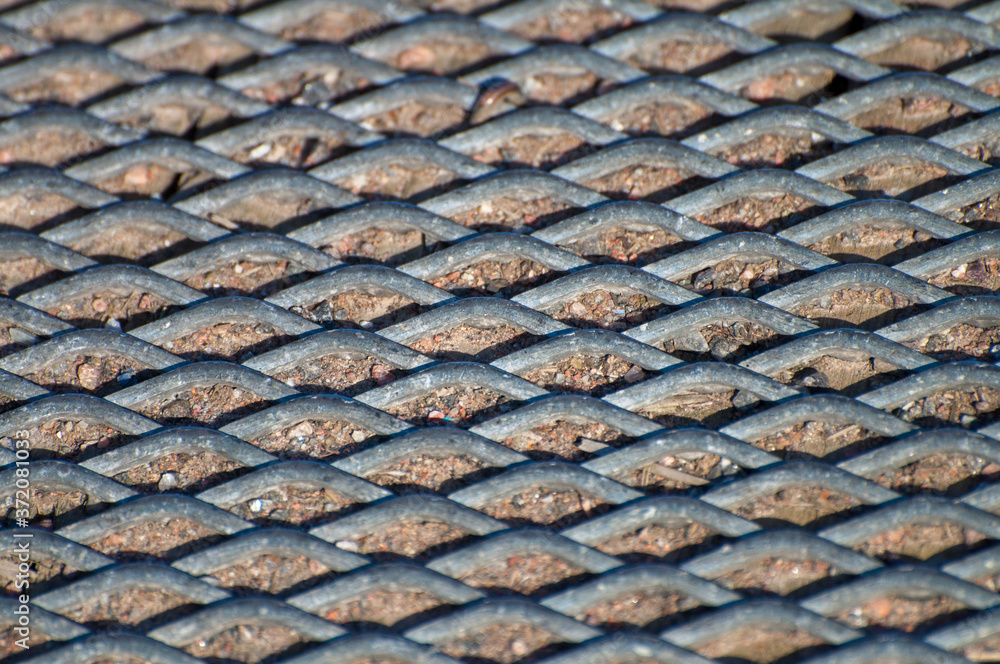 Perforated metal plate in the sand creating a texture. Perforated metal plate in the sand creating a texture.