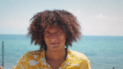 Portrait of a smiling african american young man, happy smiling latin male, Afro curly haircut. Stylish young brazilian student on street, dreadlocks dreads hair.