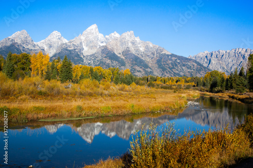 Teton mountains reflected in the Snake River in the fall
