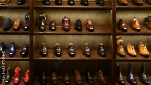 Full grain leather shoes on wooden display in men shoes boutique store. Black, brown and other colors. Zoom shot