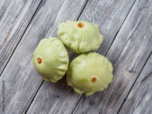 Pattypan squash on old rustic wooden background. photo