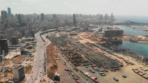 Aftermath of the Beirut port explosion, featuring a damaged grain silo, twisted metal structures, and scattered debris amid ongoing reconstruction efforts.	 photo