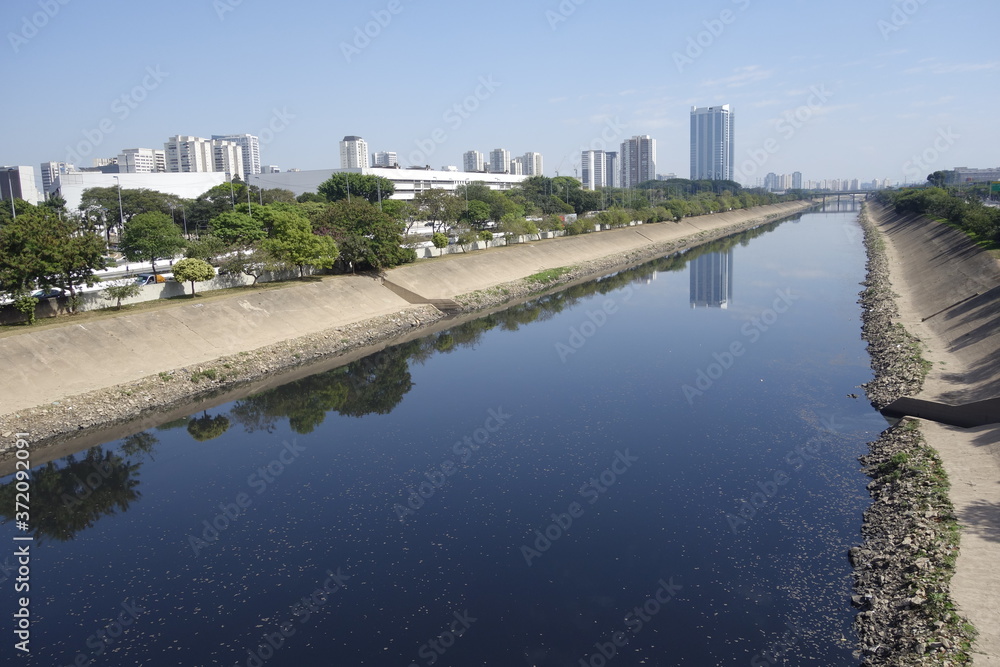 dark waters of Tiete river reflecting the sky and buildings. Sao Paulo, Brazil	
