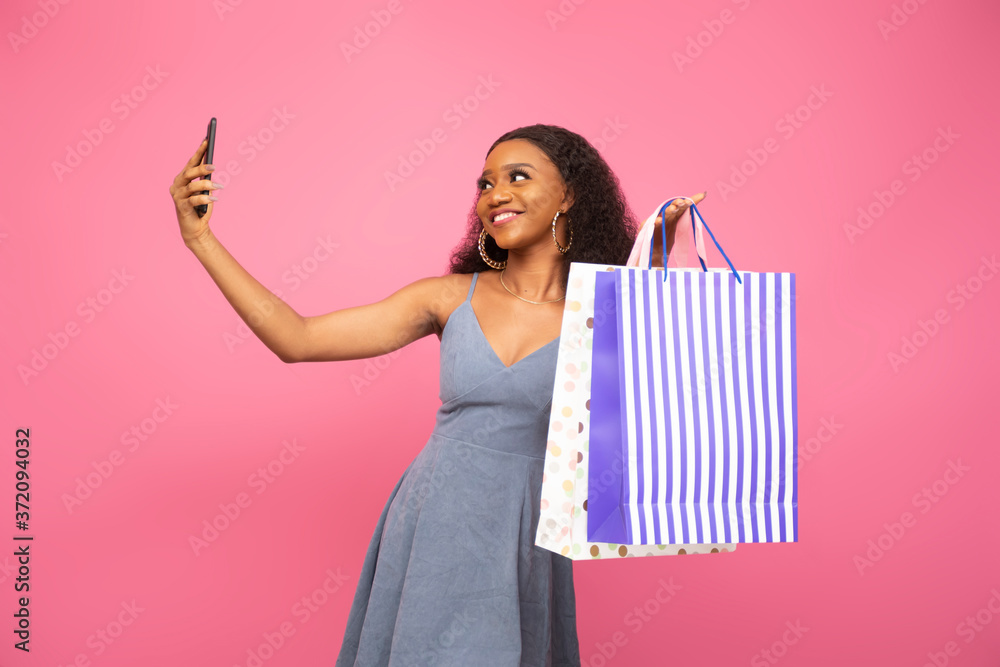 Fototapeta premium black lady carrying some shopping bags taking a selfie