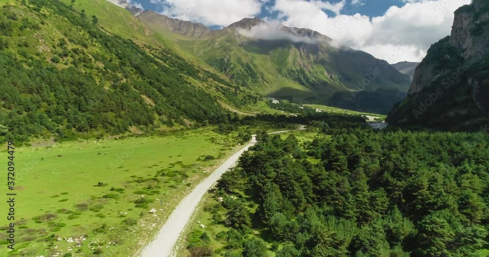 The mountain road between green slopes in the picturesque gorge. Nature and landscape of the North Caucasus The mountain road between green slopes in the picturesque gorge. Nature and landscape of the North Caucasus
