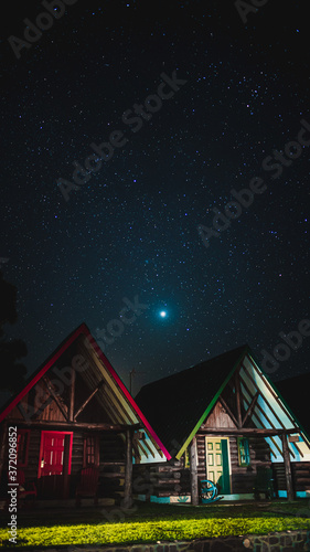 Beautiful wood cabins below a sky full of stars