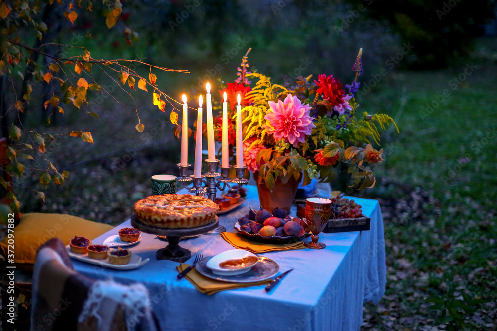 Autumn%20evening%20photo%20shoot%20-%20romantic%20dinner%20outdoors.%20Table%20with%20%20tablecloth%20and%20decoration%20-%20pie,%20figs,%20gl***es,%20plates,%20table%20setting%20and%20%20candelabra%20with%20candles.%20Fall%20flowers%20dahlia%20bouquet%20Stock%20Photo%20|%20Adobe%20%20Stock