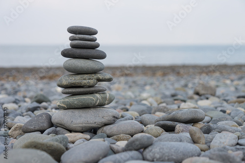 Pebbles Stack  Zen art  Rocks Tower  Pebbles tower build on the rocky beach  horizon where sky meets the sea  blurred background 