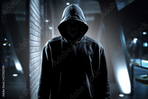 Thief in black clothes on room background photo