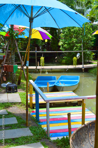 Two blue color boats on water under colorful umbrellas