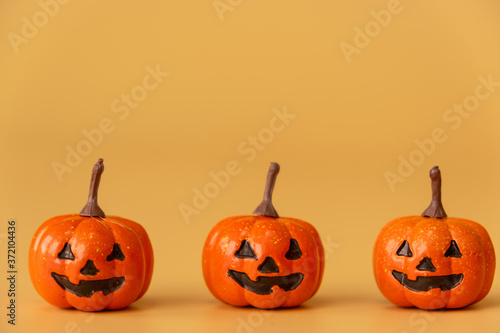 three Halloween Pumpkins on orange background