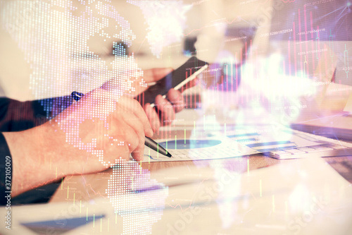 Double exposure of man's hands holding and using a phone and financial graph drawing. Analysis concept.