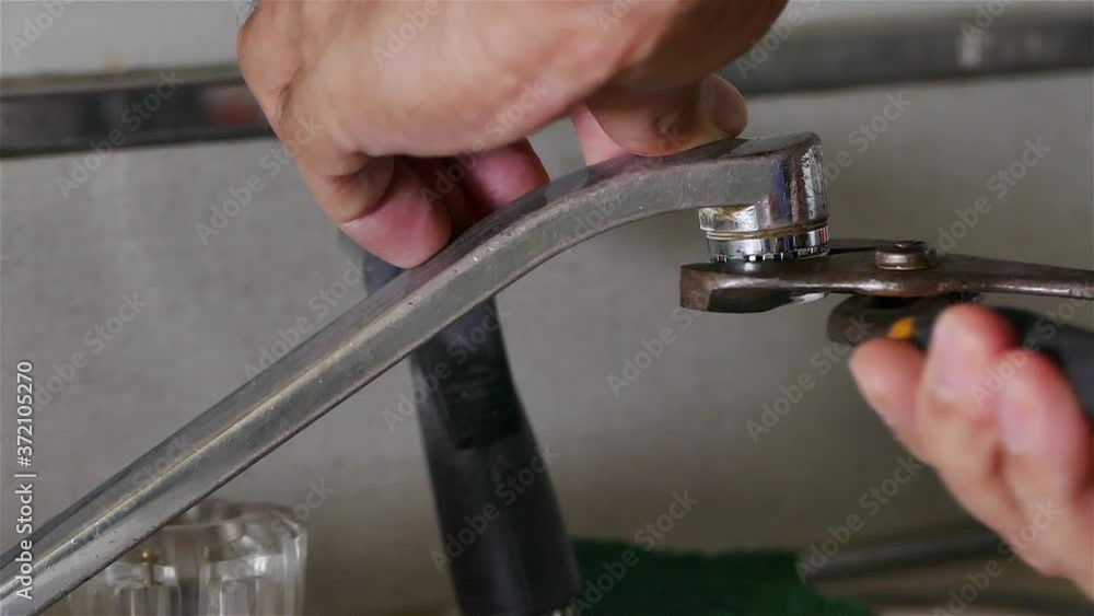 A plumber is fixing old drinking water faucet A plumber is fixing old drinking water faucet