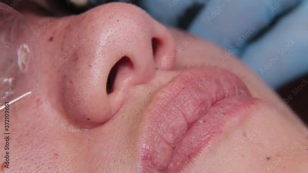 A permanent makeup artist gets a tattoo on a woman's upper eyelids. A permanent makeup artist gets a tattoo on a woman's upper eyelids.