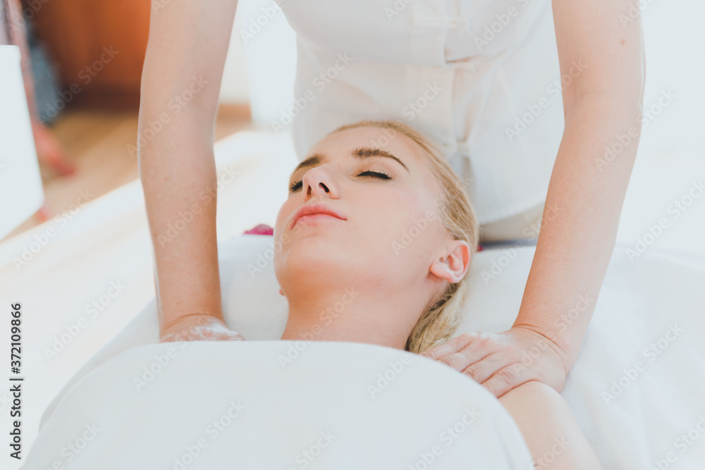 Beautiful woman lying on the bed for a spa asia massage at luxury spa and relaxation. The masseuse massaged her shoulder to the spa room Beautiful woman lying on the bed for a spa asia massage at luxury spa and relaxation. The masseuse massaged her shoulder to the spa room