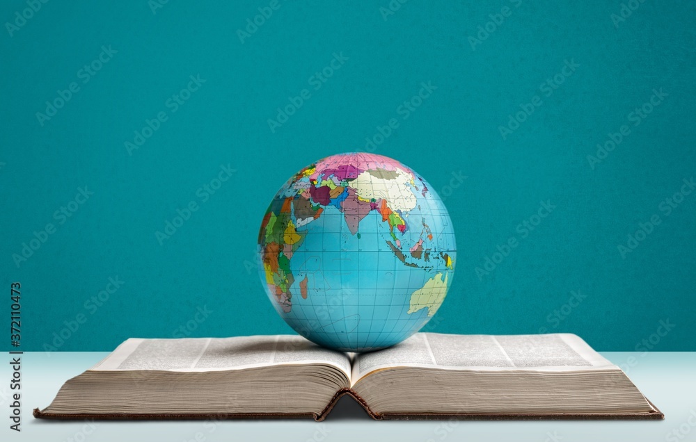 Heavy book and globe of a planet on the desk Heavy book and globe of a planet on the desk