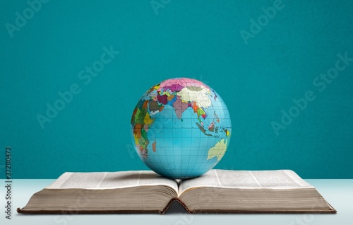 Heavy book and globe of a planet on the desk photo