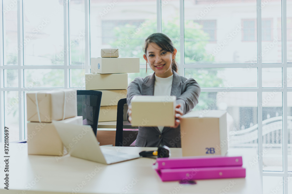 A beautiful businesswoman working at home is checking orders for products to be delivered to her customers from notebooks. A beautiful businesswoman working at home is checking orders for products to be delivered to her customers from notebooks.