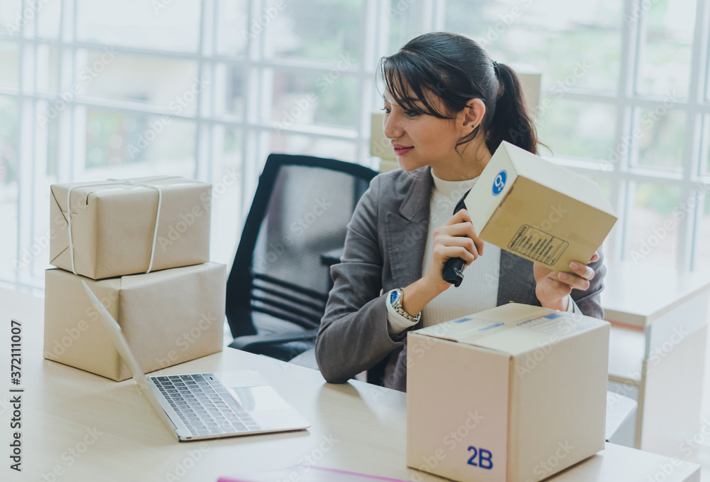 A beautiful businesswoman working at home is checking the amount of products that will be delivered to her customers. A beautiful businesswoman working at home is checking the amount of products that will be delivered to her customers.