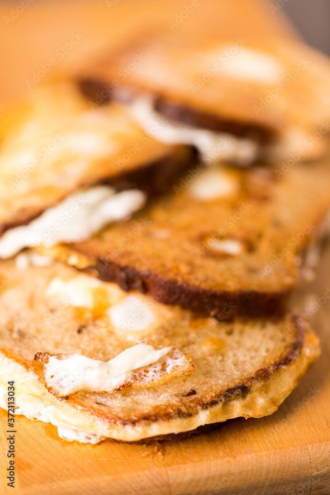 Large Number of Tasty Slices of Traditional Fried Bread With Fried Eggs Together. Over Wooden Board Indoors.Shallow Depth Of Field. Large Number of Tasty Slices of Traditional Fried Bread With Fried Eggs Together. Over Wooden Board Indoors.Shallow Depth Of Field.
