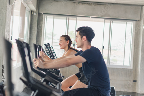 Male and female athletes talk about exercise  cycling in the gym. They wear sportswear to exercise.