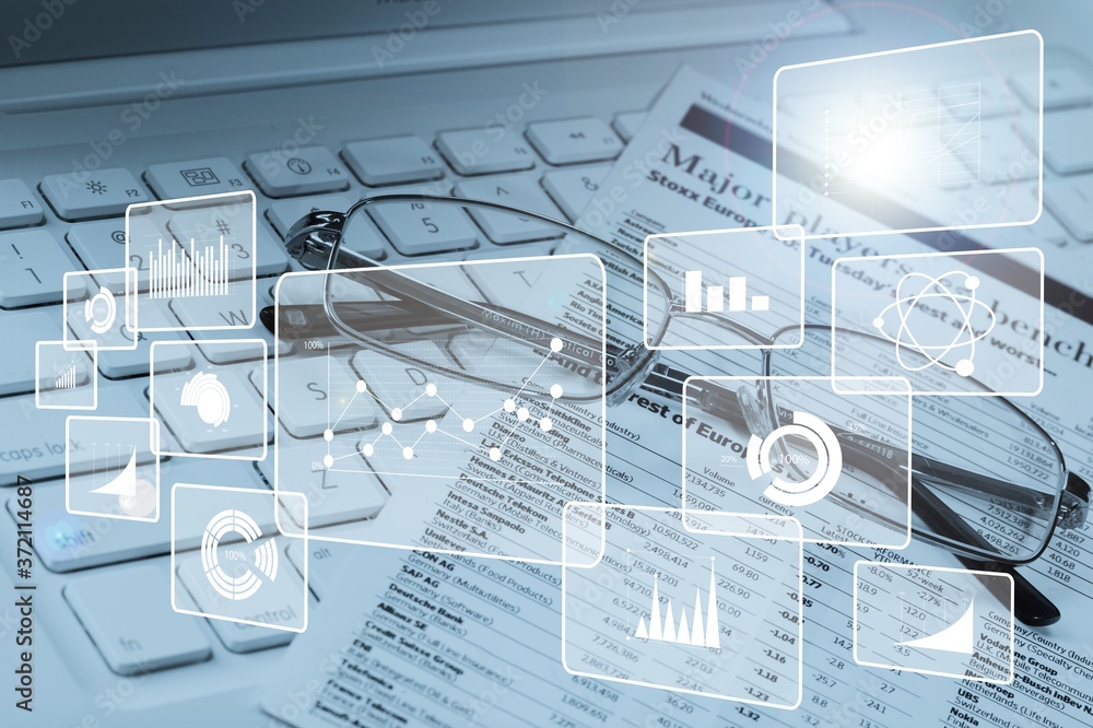 Fototapeta premium Glasses and papers on keyboard of modern laptop