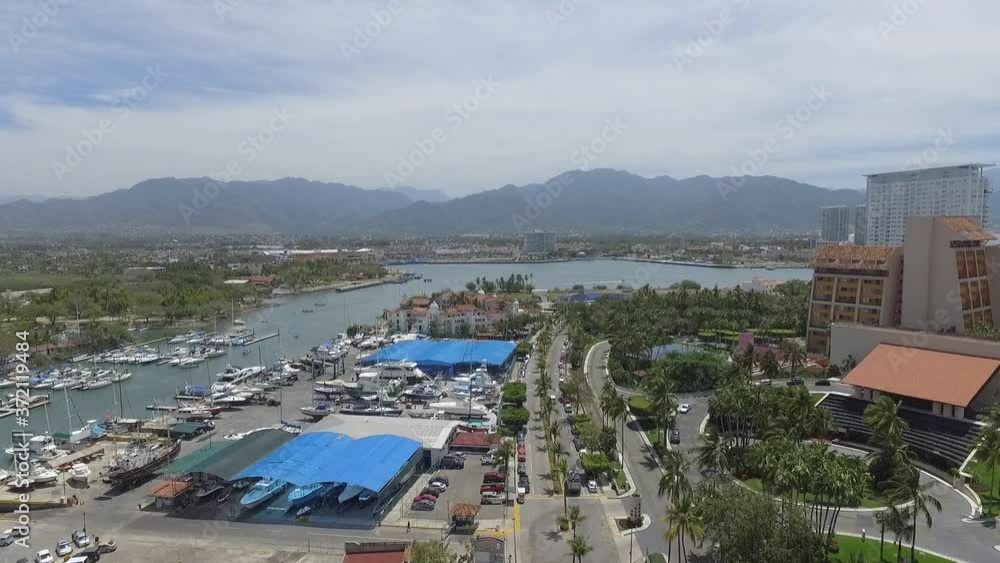 Vista aérea del embarcadro y zona de acceso a la marina de Puerto Vallarta, Jalisco. El drone ascendiendo lentamente. Vista aérea del embarcadro y zona de acceso a la marina de Puerto Vallarta, Jalisco. El drone ascendiendo lentamente.