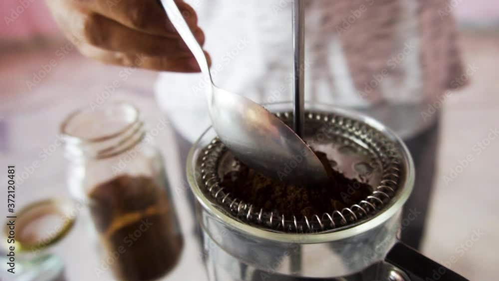 Man using spoon for adding coffee powder Man using spoon for adding coffee powder