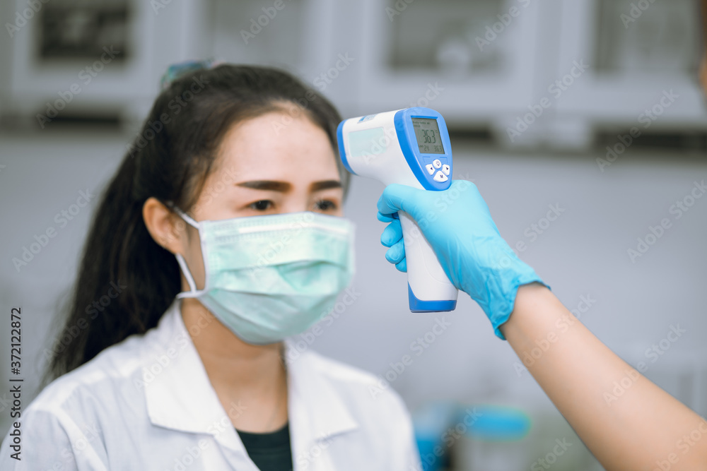 Staff using Digital Infrared Thermometer(thermometer gun ) for measure temperature worker before starting work , concept of screening for Coronavirus or COVID-19 infection. Staff using Digital Infrared Thermometer(thermometer gun ) for measure temperature worker before starting work , concept of screening for Coronavirus or COVID-19 infection.