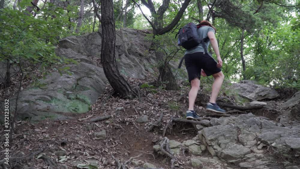 Male Hiker Walking up A Rocky Mountain With Narrow Path - Medium Shot Male Hiker Walking up A Rocky Mountain With Narrow Path - Medium Shot